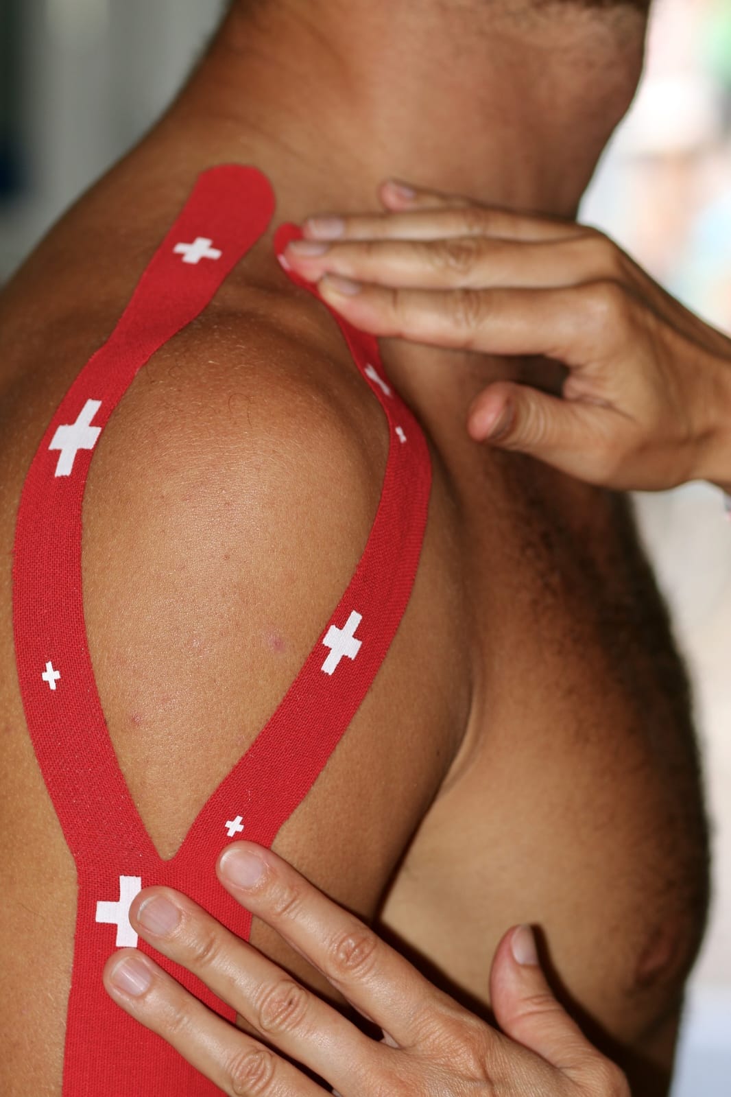 Rotes Kinesiotape an der Schulter