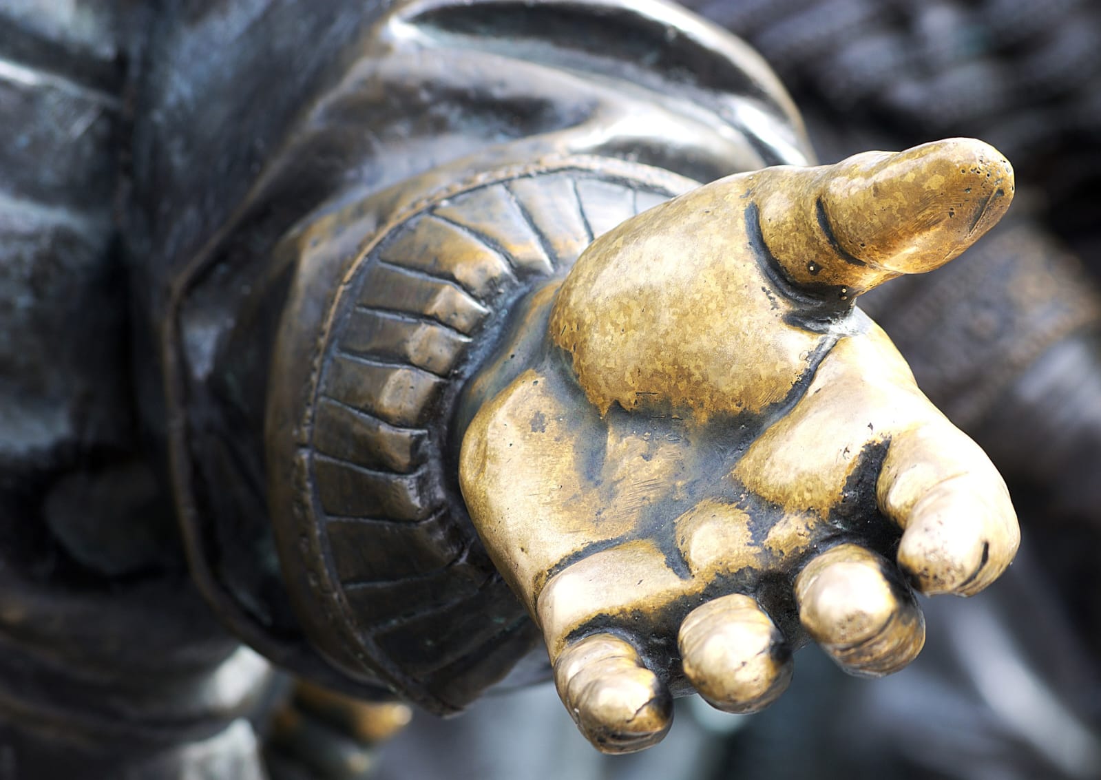 Offene helfende Hand einer Bronzefigur